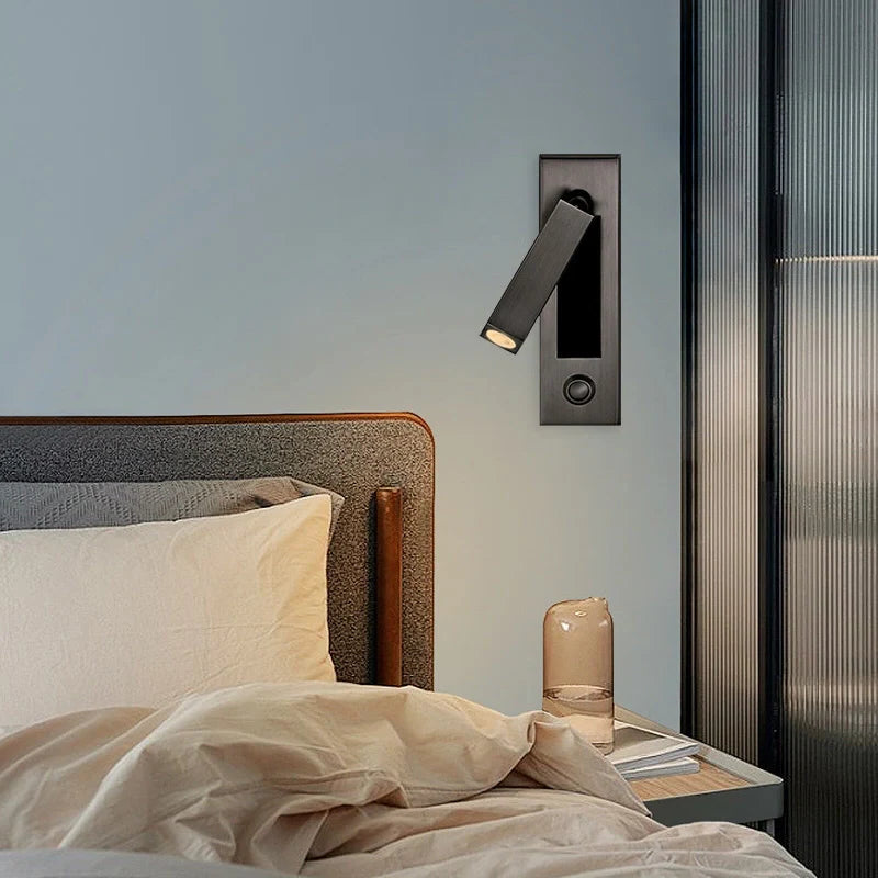 Bedroom scene with a wall-mounted light fixture above a bed.