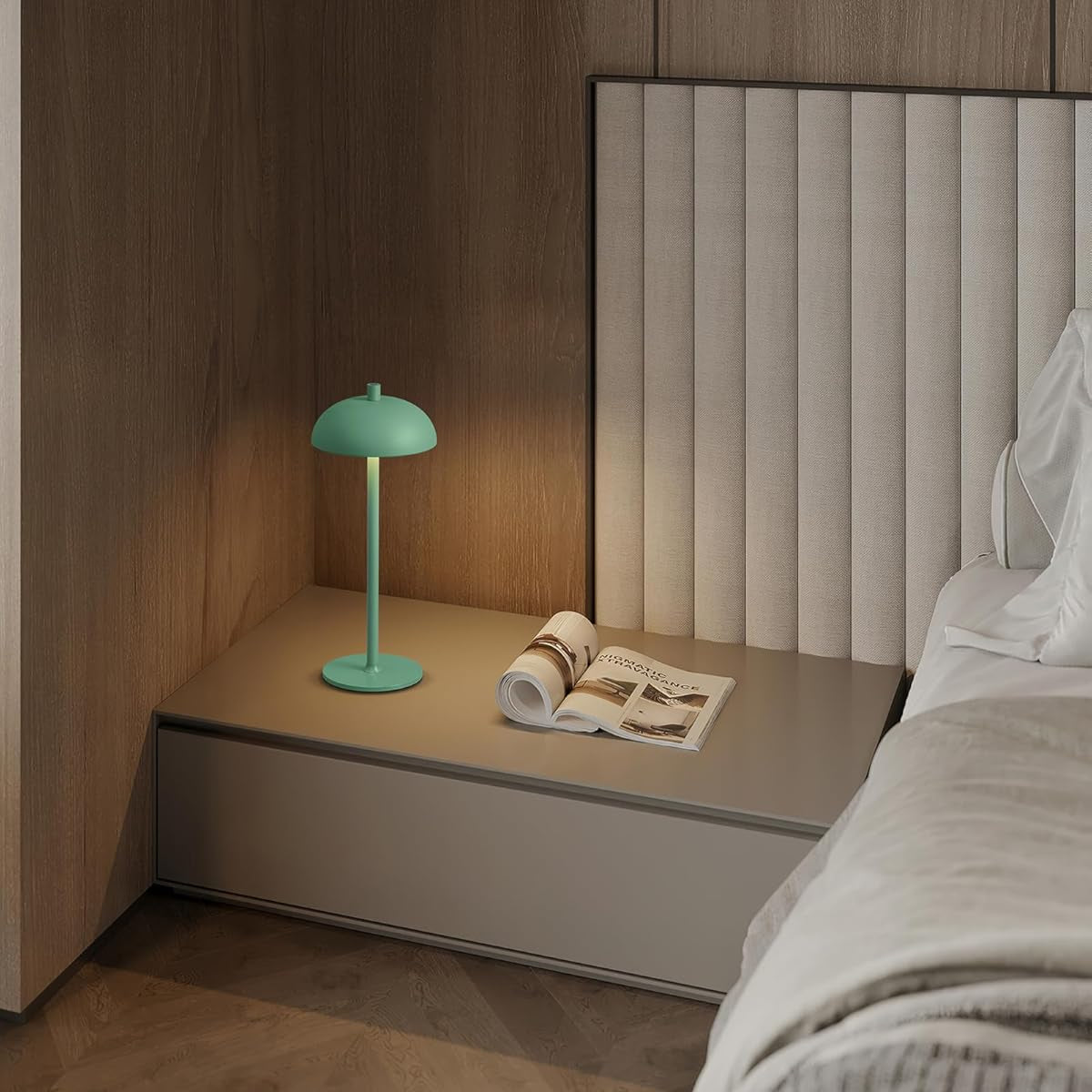 Green lamp on a nightstand next to a bed with a wooden headboard