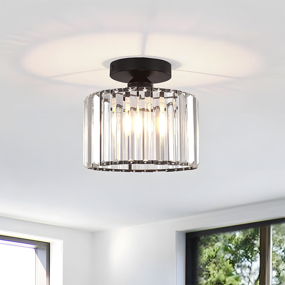 Ceiling light fixture with clear glass shade and black metal fixture in a room with windows.