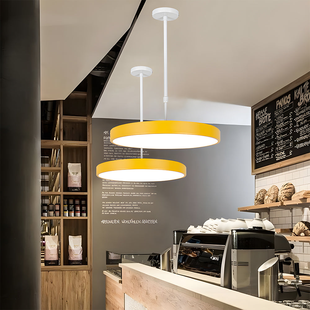 Modern cafe interior with yellow pendant lights, coffee machine, and menu board.