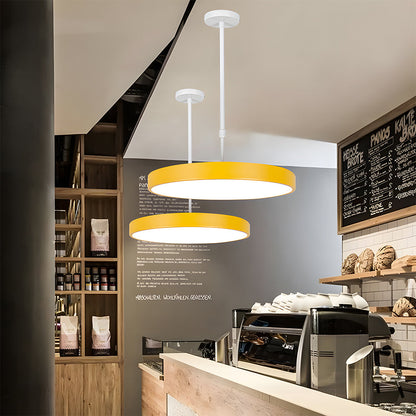 Modern cafe interior with yellow pendant lights, coffee machine, and menu board.