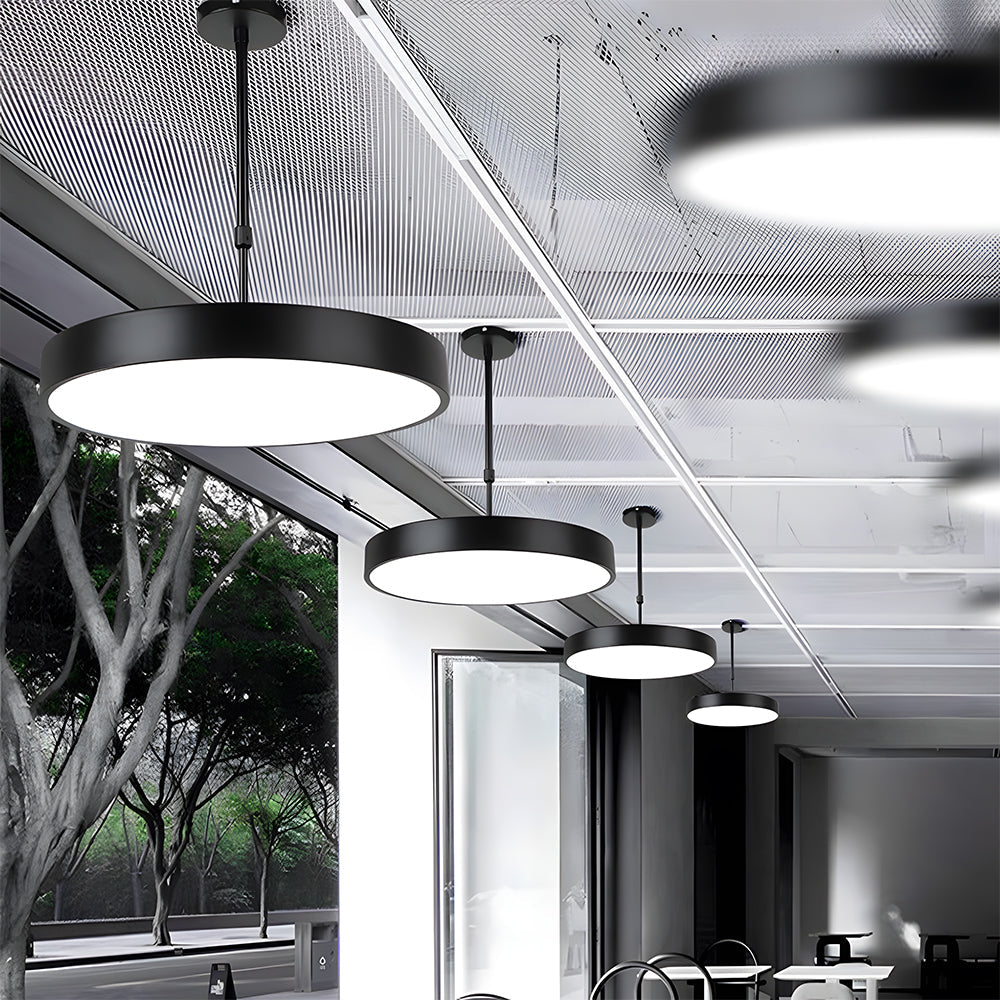 Modern office interior with pendant lights and large windows.