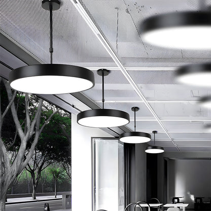 Modern office interior with pendant lights and large windows.