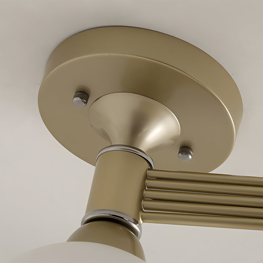 Close-up of a beige ceiling light fixture with metallic arms.