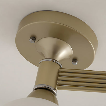 Close-up of a beige ceiling light fixture with metallic arms.