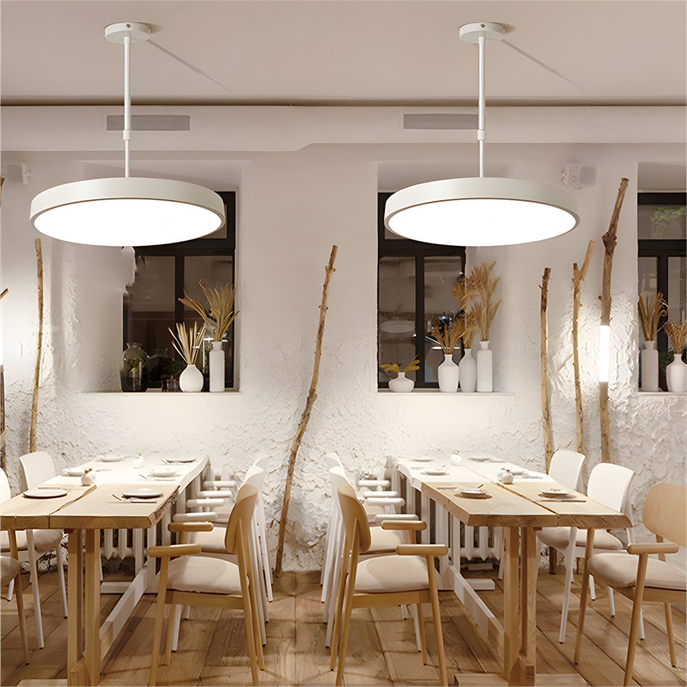 Modern restaurant interior with wooden tables, chairs, and pendant lights.