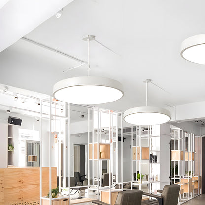 Modern office interior with white pendant lights and glass partitions.