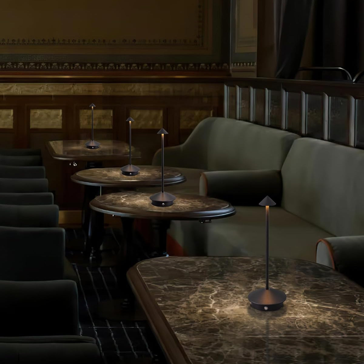 Dark and moody interior of a restaurant with dim lighting and marble tables.
