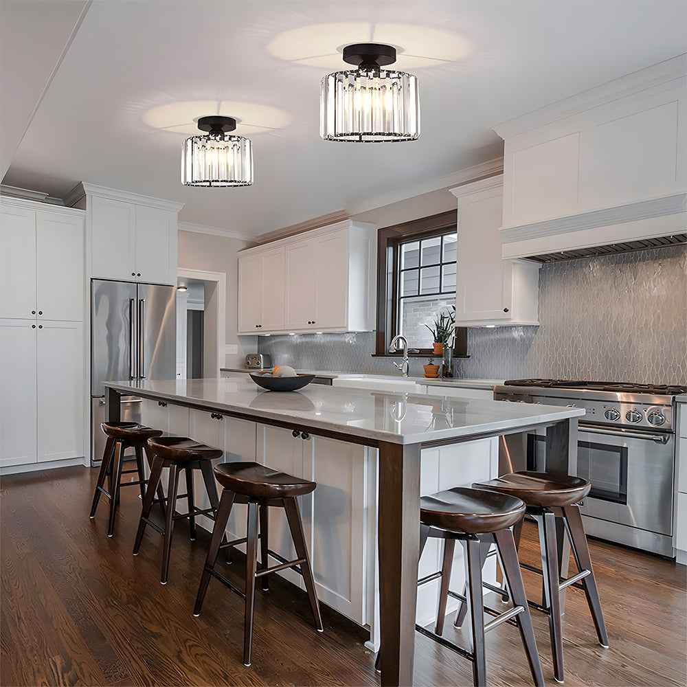 Modern kitchen with island, stools, and stainless steel appliances.