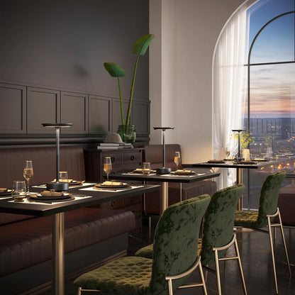 Modern dining room with green chairs and a large window view.