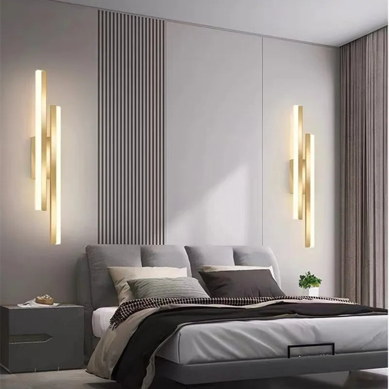 Modern bedroom with a bed, wall lights, and decorative elements.
