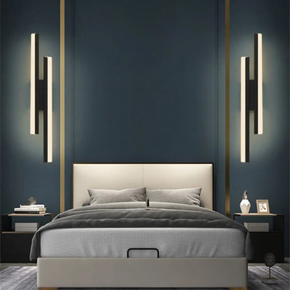 Modern bedroom with a bed, nightstands, and wall lights against a dark blue wall.