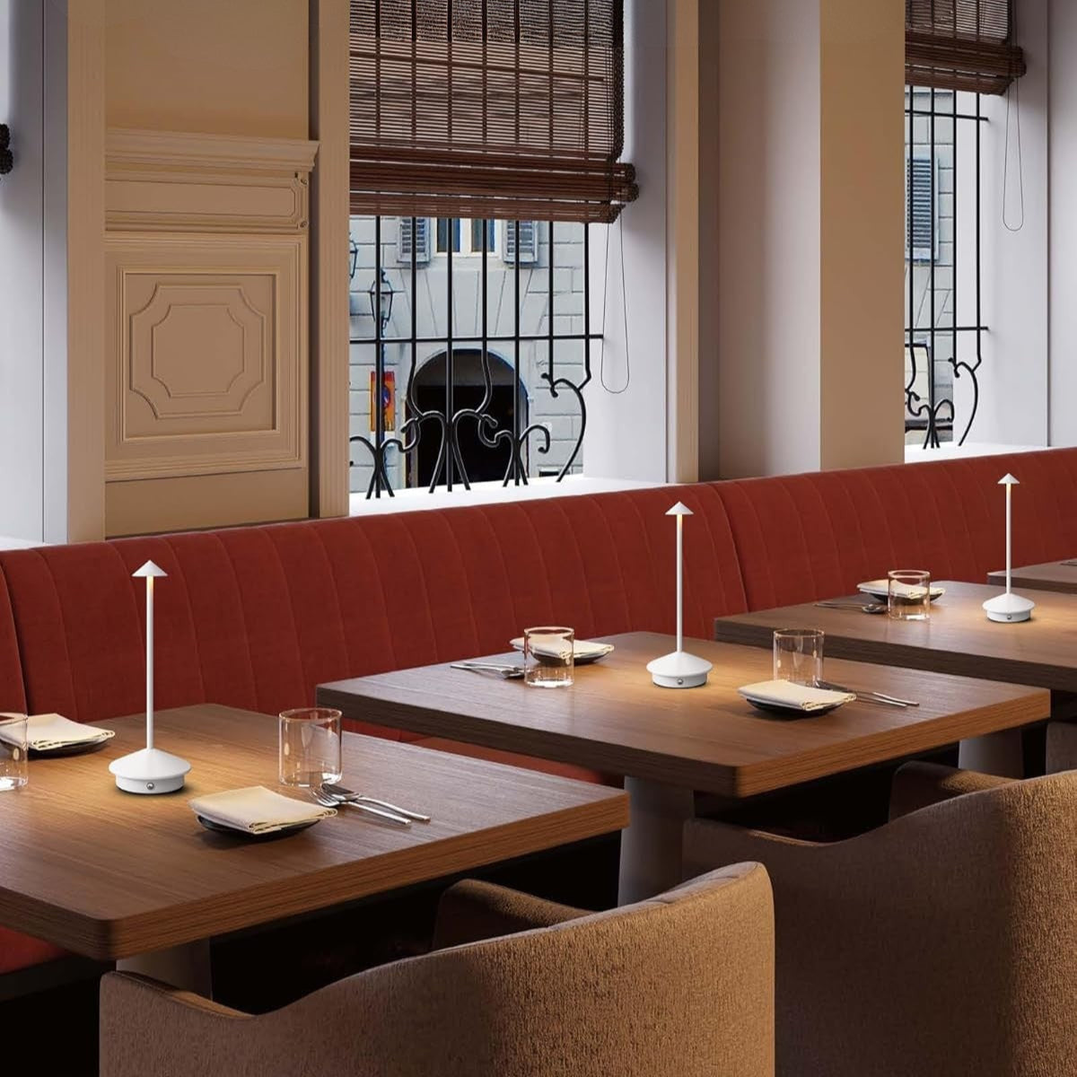 Restaurant interior with wooden tables, red booth seating, and large windows.