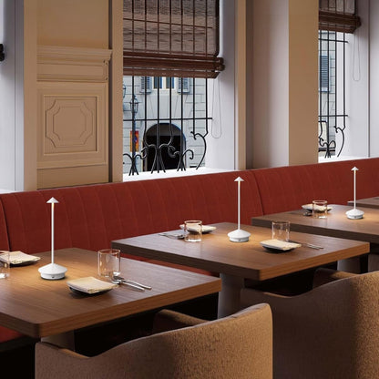 Restaurant interior with wooden tables, red booth seating, and large windows.