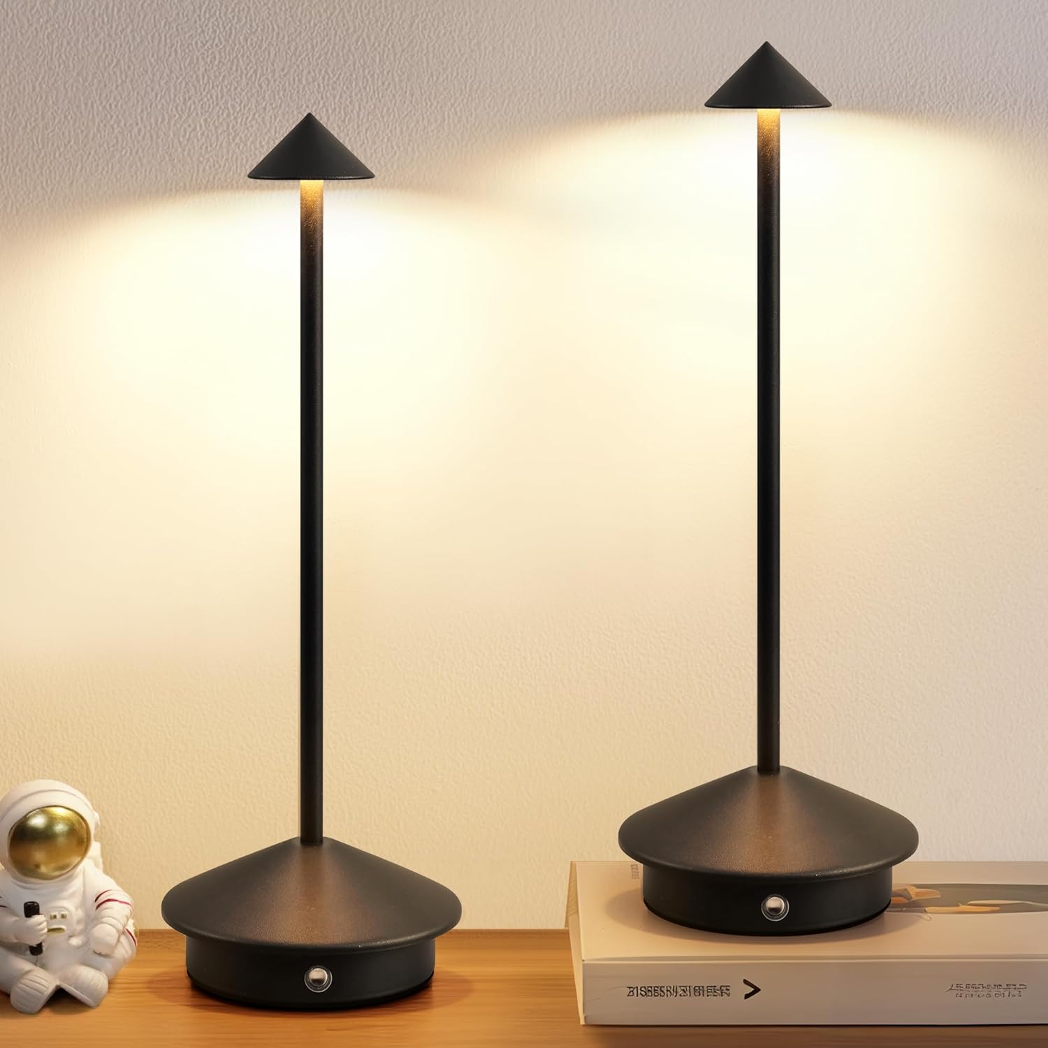 Two black table lamps on a wooden surface with a soft light background.
