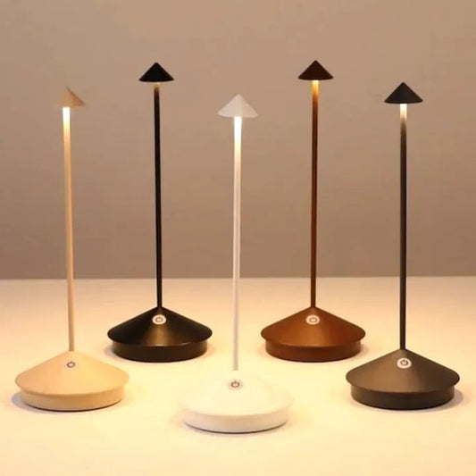 Set of five modern desk lamps with different base colors on a neutral background