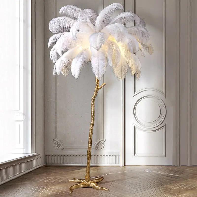 Decorative floor lamp with white feathers and gold base in a room with wooden flooring and white walls.